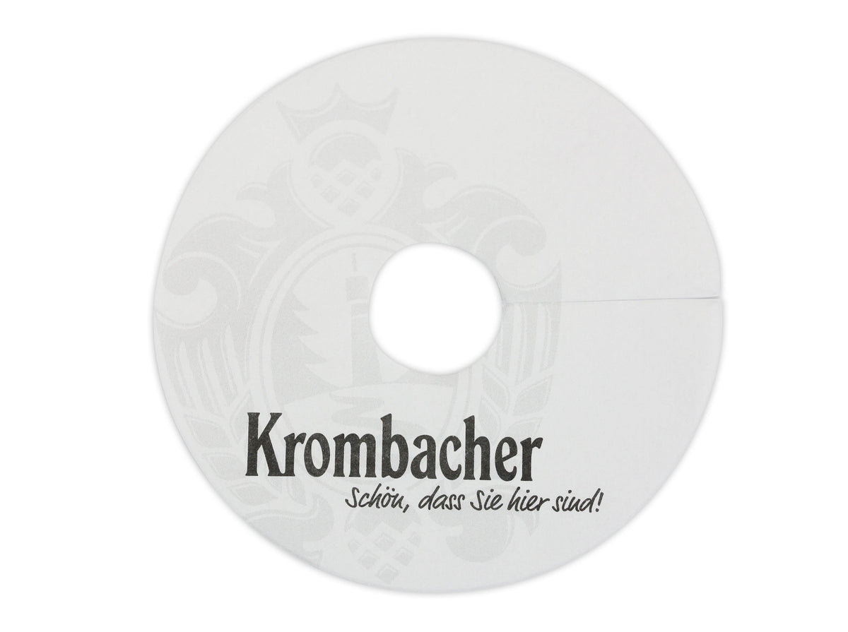 Weiße Krombacher Tropfendeckchen mit schwarzem Schriftzug und hellgrauem Wappen.