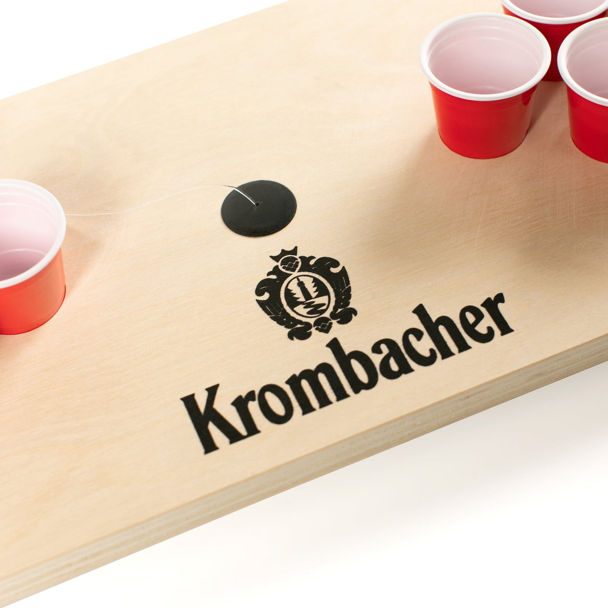Nachaufnahme Krombacher Mini Beerpong Spiel mit roten Bechern auf Holzplatte.