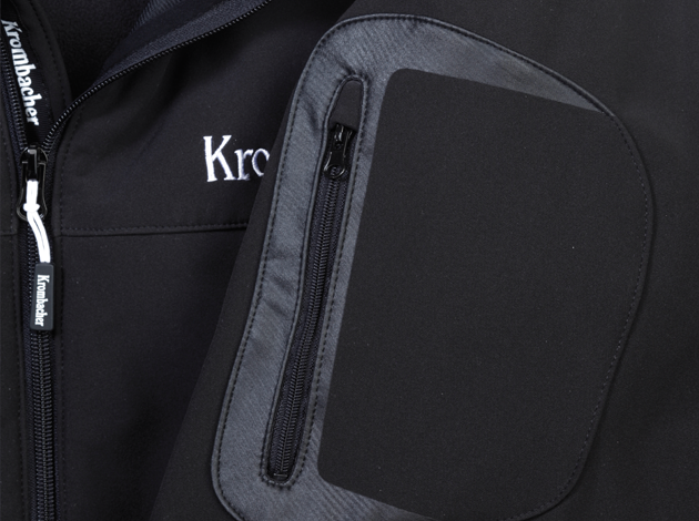 Ausschnitt einer schwarzen Softshelljacke mit Reißverschluss und aufgesetzter Tasche mit Reißverschlus