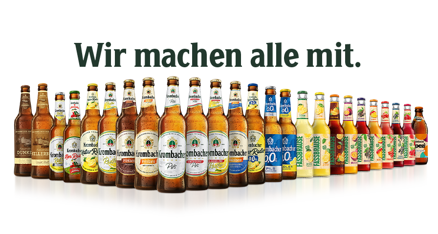 Verschiedene Krombacher Bierflaschen und alkoholfreie Getränke in einer Reihe mit dem Text 'Wir machen alle mit.'