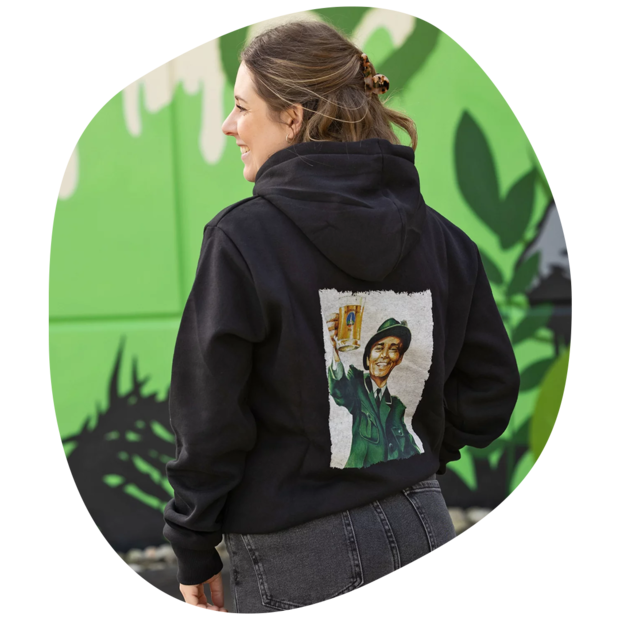 Person trägt schwarzen Kapuzenpullover mit Grafik eines Försters, der ein Bierglas hält, auf dem Rücken