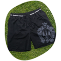 Schwarze Badeshorts mit Kordelzug und weißem Schriftzug 'Krombacher' am Bund, großes Wappenlogo auf dem linken Bein, liegend auf Gras