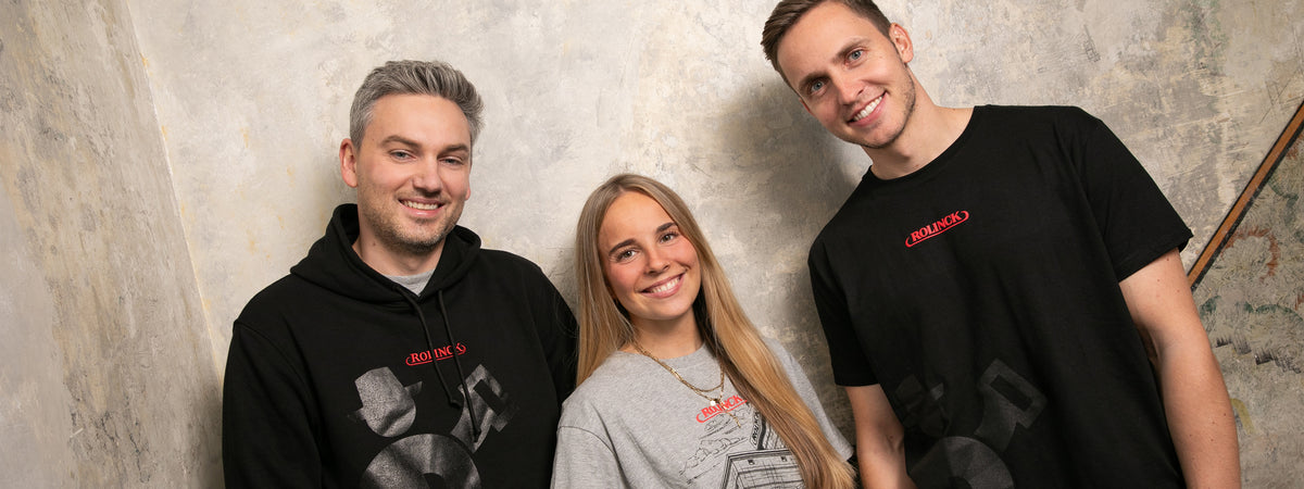 Rolinck Bekleidung mit grauem Print-Shirt, schwarzem Logo-Shirt und schwarzem Hoodie.