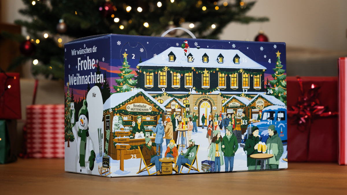 Krombacher Adventskalender mit winterlichem Weihnachtsmarkt-Motiv, Weihnachtsbaum und Geschenken im Hintergrund.