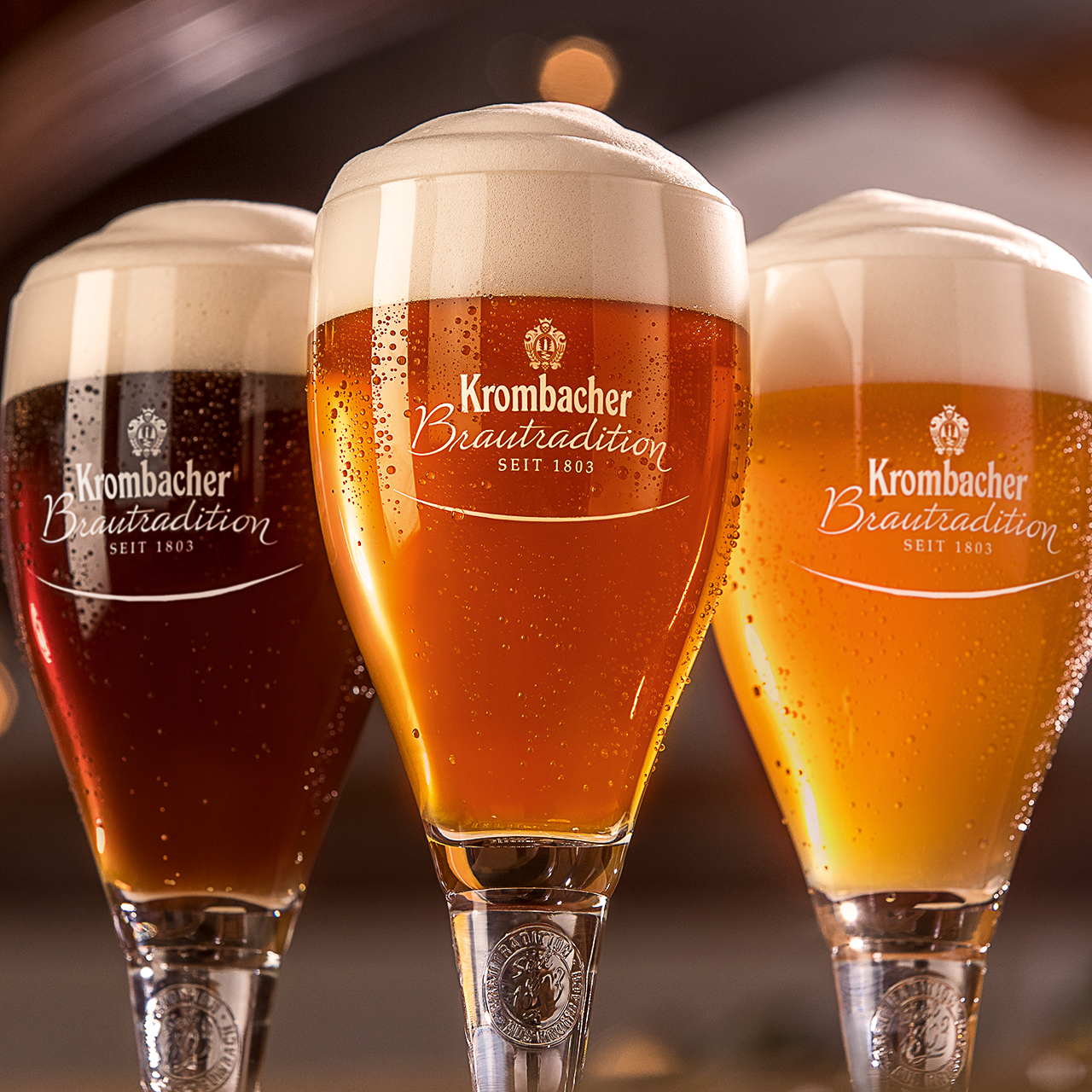 Drei Traditionspokale mit Krombacher Bier, verschiedene Sorten von dunkel bis hell.
