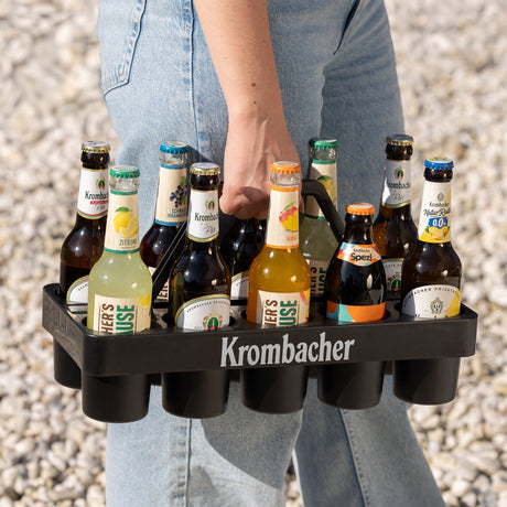 Eine Frau trägt den Krombacher Gläser-Träger, gefüllt mit Flaschen.