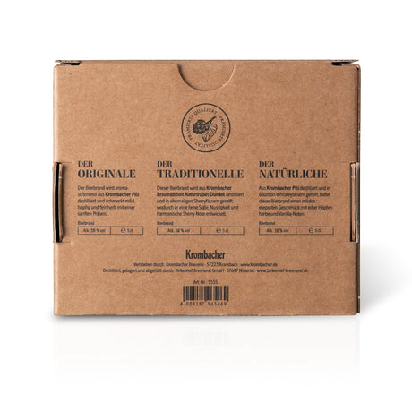Rückseite braune Kartonverpackung mit drei Beschreibungen zu Krombacher Probierbrand-Sorten: Der Originale, Der Traditionelle, Der Natürliche, jeweils 5 cl, 38,5 % Vol.