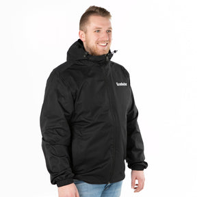 Person trägt schwarze Krombacher Regenjacke mit Kapuze und Reißverschluss, dazu blaue Jeans.