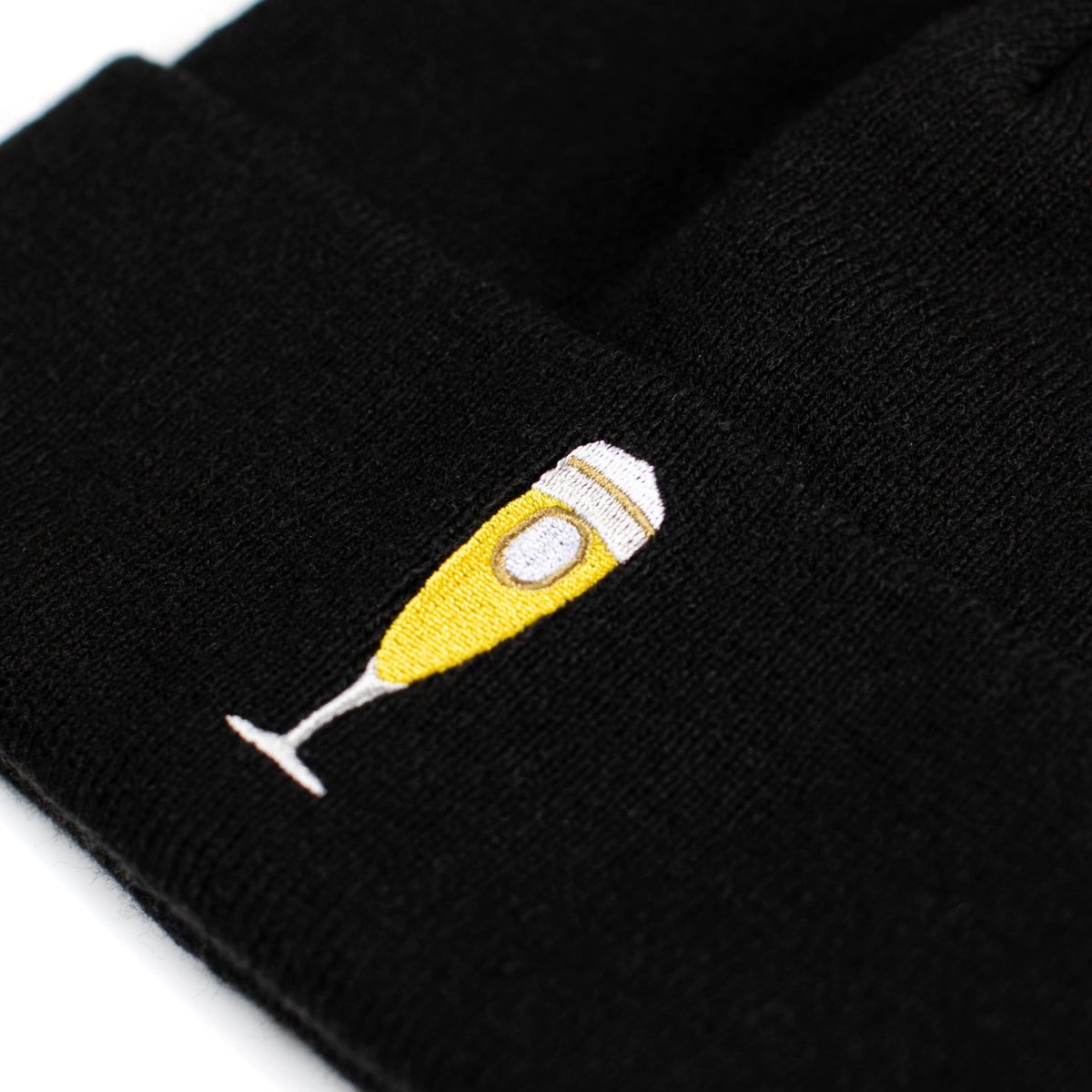 Schwarze Beanie mit gesticktem gelbem Bierglas auf der Umschlagkante.