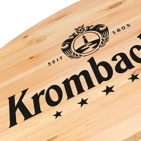 Nahaufnahme von Holzplatte vom Stehtisch mit schwarzem Krombacher-Logo aufgedruckt.