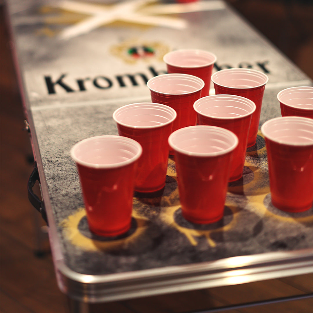 Roter Becher-Pyramide auf einem Beer-Pong-Tisch mit Krombacher-Logo.