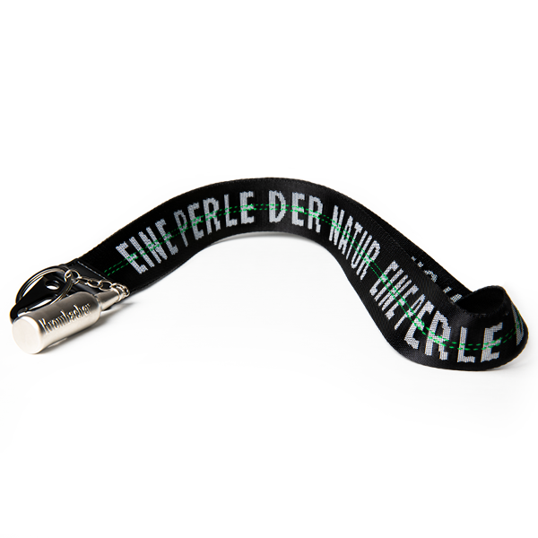Schwarzes Schlüsselband mit silbernem Flaschenöffner und der Aufschrift 'EINE PERLE DER NATUR' in grüner und weißer Schrift