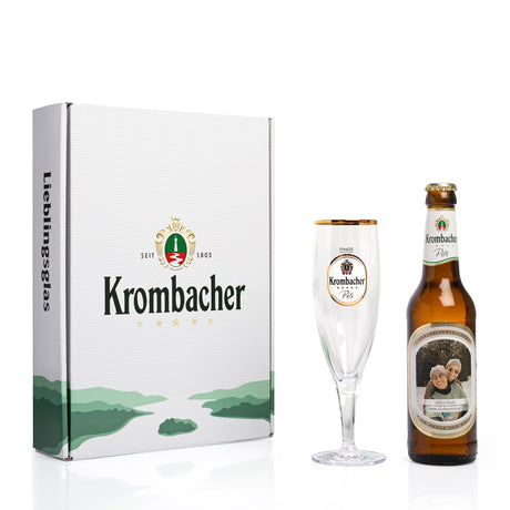 Weiße Verpackung mit grünem Landschaftsmotiv und Schriftzug "Krombacher", daneben ein Krombacher-Pils-Flasche und ein Krombacher-Pils-Glas mit goldfarbenem Rand