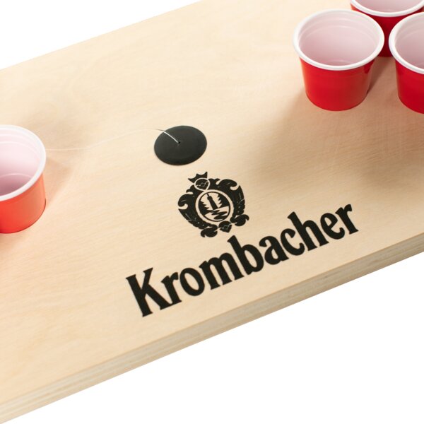 Nachaufnahme Krombacher Mini Beerpong Spiel mit roten Bechern auf Holzplatte.