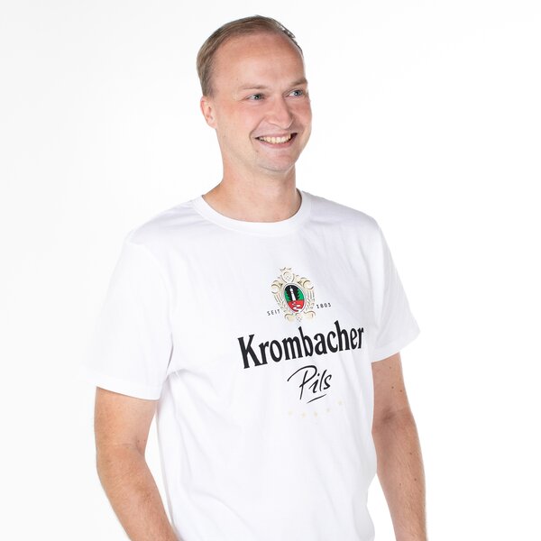 Ein Mann in einem weißen T-Shirt mit Krombacher Pils Logo auf der Brust.