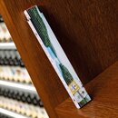 Zollstock mit Landschaftsbild und Krombacher-Logo, auf Holzregal gelehnt.