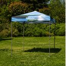 Blauer Pavillon mit Krombacher-Logo und Schriftzug 'Eine Perle der Natur' auf einer grünen Wiese vor Bäumen.