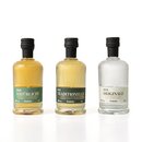 Drei kleine Krombacher Probierbrand-Flaschen mit schwarzen Verschlüssen, beschriftet als 'Der Natürliche', 'Der Traditionelle' und 'Der Originale'.