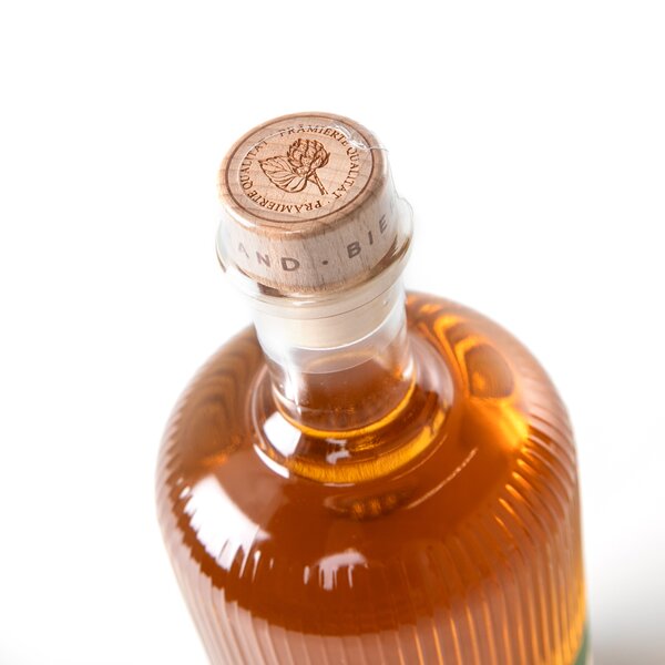 Flasche mit bernsteinfarbener Flüssigkeit, Holzverschluss mit Prägung.