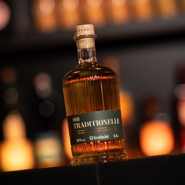 Flasche Krombacher Bierbrand 'Der Traditionelle' mit 38% Vol., 0,5 Liter, gerilltes Glas und schwarzes Etikett mit weißem Text.