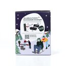 7483_krombachershop_Adventskalender_Produkt_005 Seitenansicht des Krombacher Adventskalenders mit Illustration von zwei Personen auf einem Schlitten im Schnee, Tannenbäumen und Text zum Krombacher Adventskalender-Gewinnspiel.