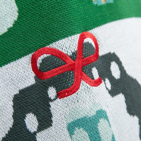 Nahaufnahme eines Strickstoffs mit grünem Rand und roter Schleife als Stickerei.