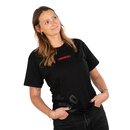 Frau trägt schwarzes T-Shirt mit rotem Schriftzug 'Rolinch' und dunkle Jeans, Hände in den Hosentaschen.