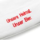 Nahaufnahme von Socke mit roter Stickerei 'Unsere Heimat Unser Bier' in diagonaler Schrift.