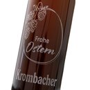 Braune Flasche mit der gravierter Aufschrift 'Frohe Ostern' und 'Krombacher' sowie einer Illustration von Hopfenzapfen und einem Osterei