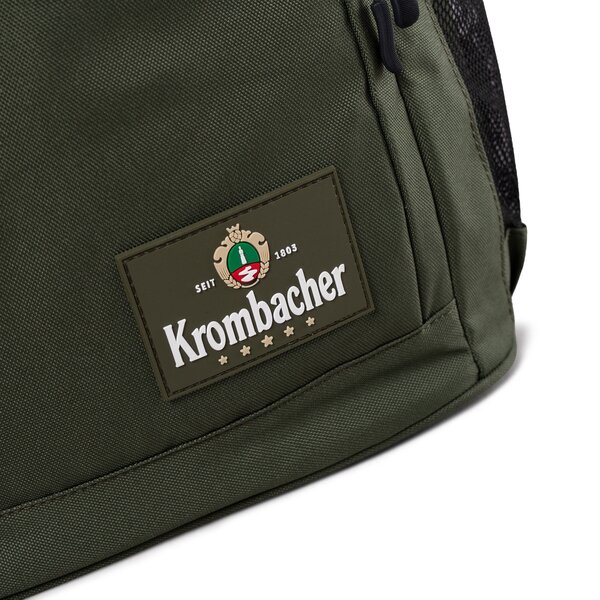 Grüner Rucksack mit aufgenähtem Krombacher-Logo.