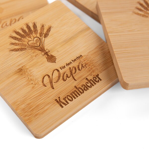 Untersetzer aus Holz mit Gravur eines Weizenbündels und der Schrift 'Für den besten Papa Krombacher'.