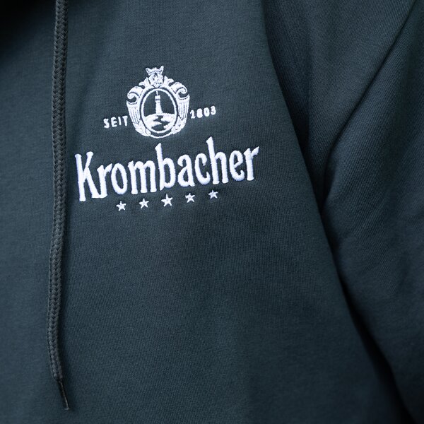 Dunkelblaue Kapuzenjacke mit weißem Krombacher-Logo und Schriftzug auf der Brust