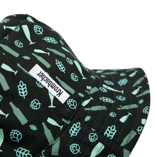 Dunkel grüner Bucket Hat mit hellblau-grünen Mustern aus Bierflaschen, Biergläsern und Hopfendolden sowie einem weißen Krombacher-Logoetikett