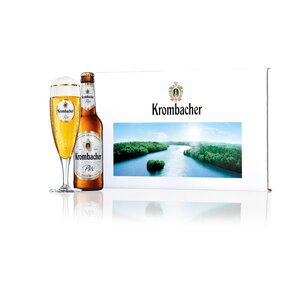 Krombacher Pils Bierflasche und Glas, neben einer Krombacher Geschenkbox mit Krombacher See Aufdruck.