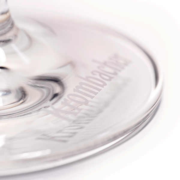 Fuß eines Glases mit eingraviertem Schriftzug 'Krombacher'.