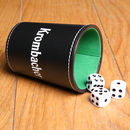  Krombacher Würfelbecher liegt gekippt auf einem Holztisch, Würfel liegen daneben. 